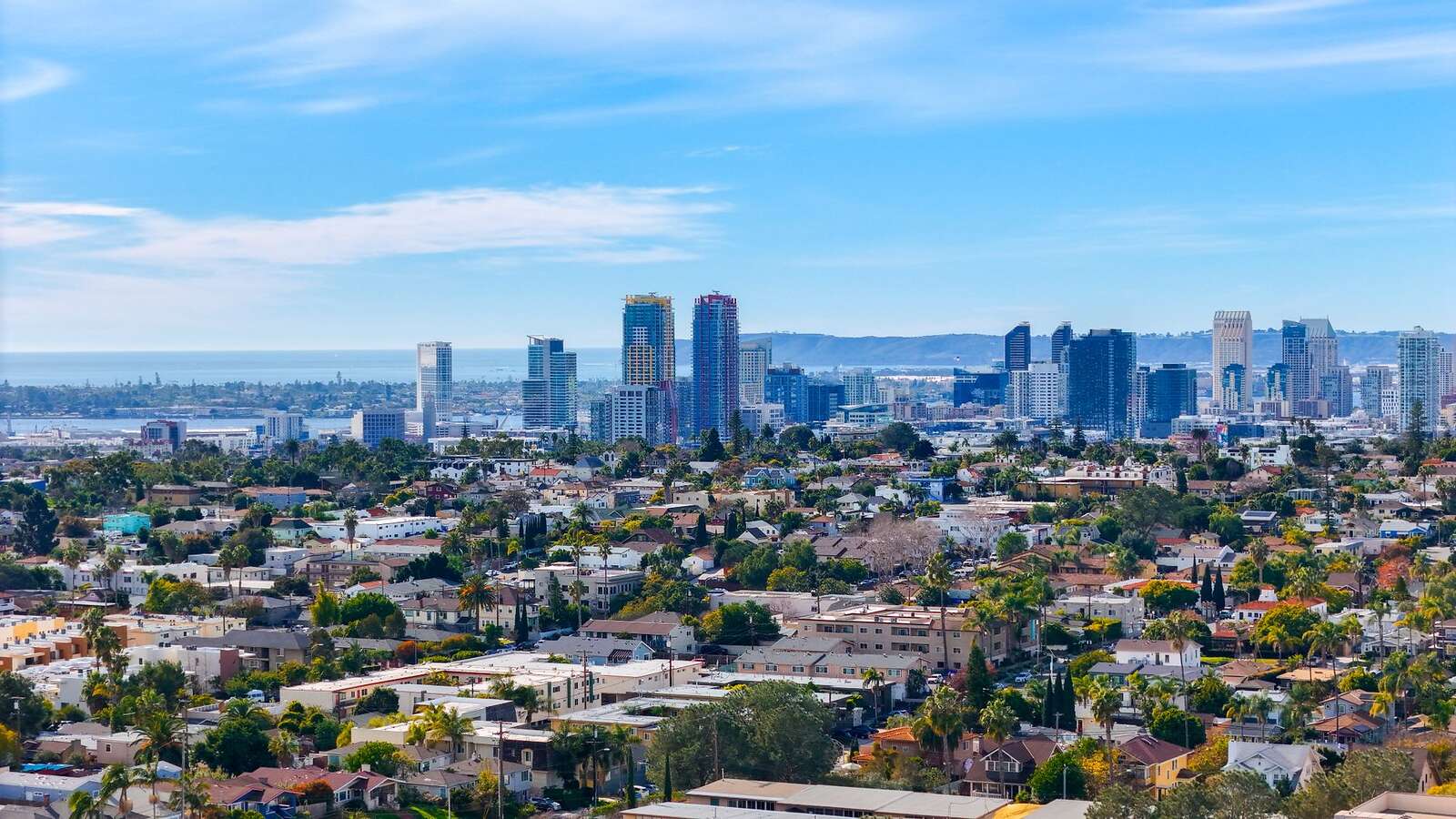 Aerial view of downtown San Diego with the neighborhoods and canyons spreading behind it